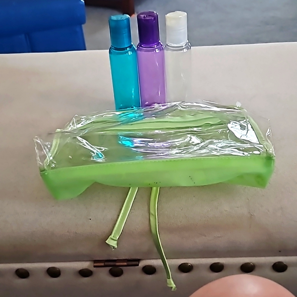 Zippered makeup bag with 3 plastic bottles.